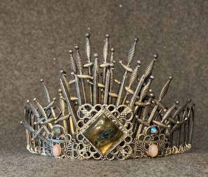 Silver tiara made from swords on a gray background Silver tiara made from swords on a gray background