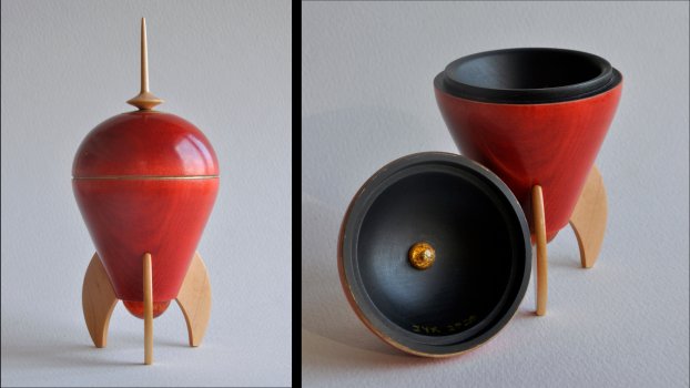 Spaceship-shaped maple wood box. Dyed red with gold ink accents and a black interior. Spaceship-shaped maple wood box. Dyed red with gold ink accents and a black interior.